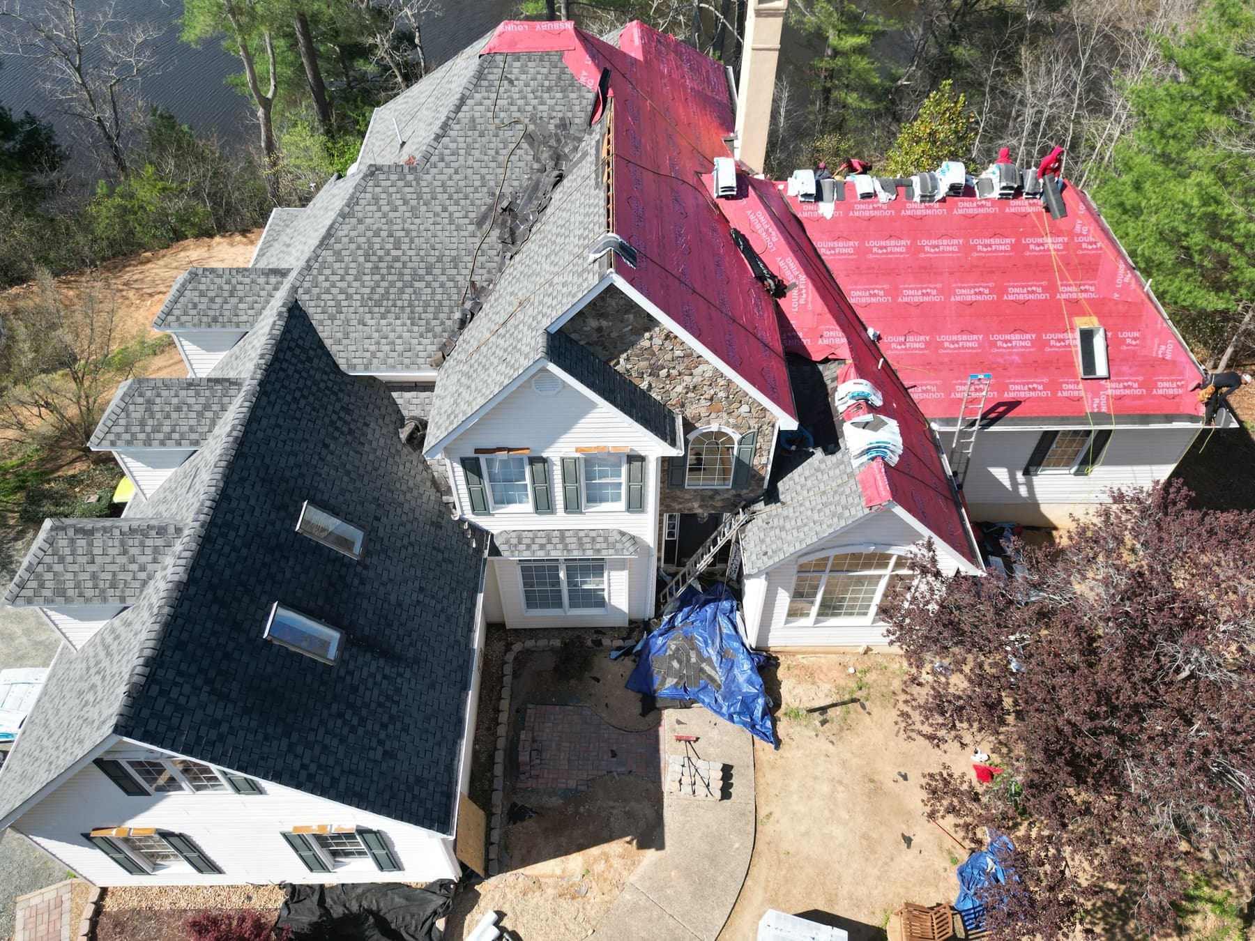 Aerial view of a large Keswick-area estate mid-reroof, asphalt shingles being installed by Lounsbury Roofing